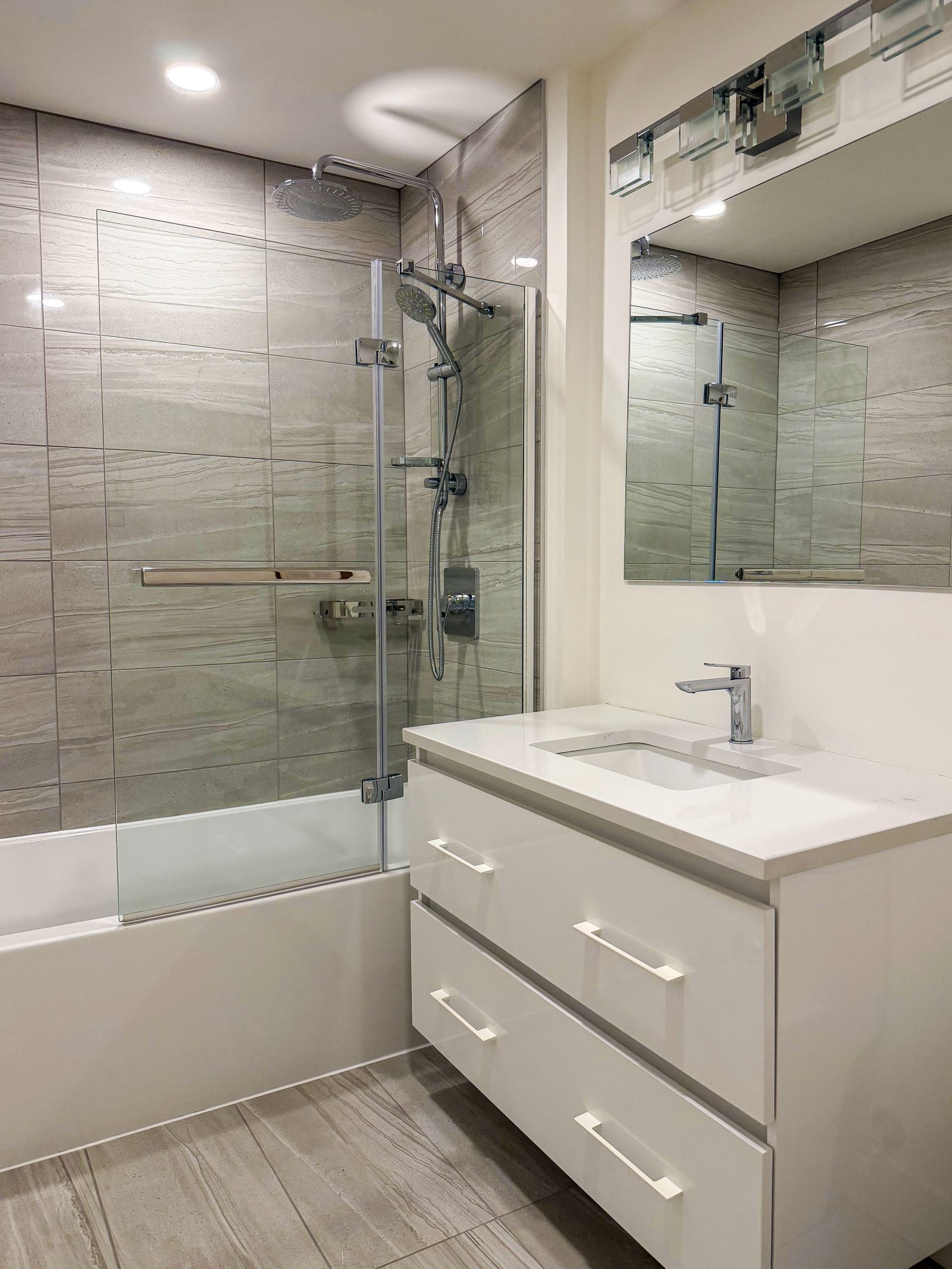 Second full bathroom with glass shower and grey tile