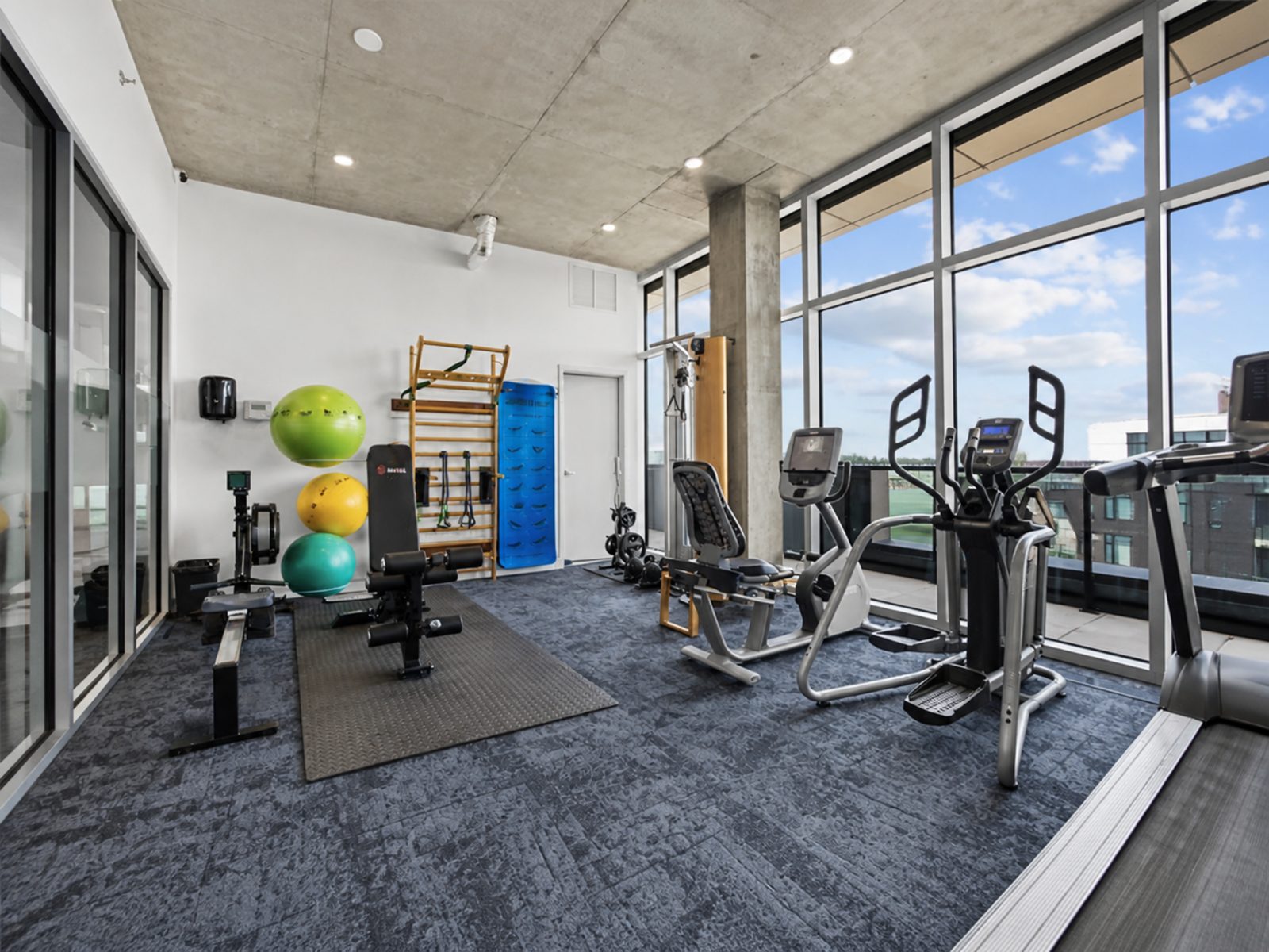 Glass-walled fitness room with concrete ceiling